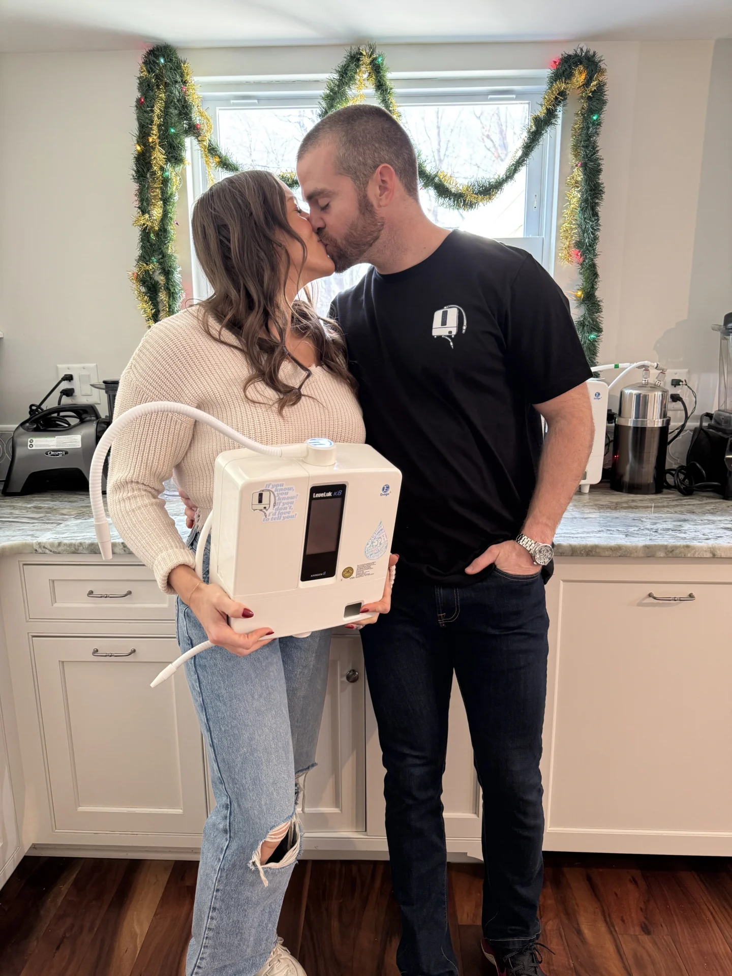 The Kangen Couple kissing in their kitchen